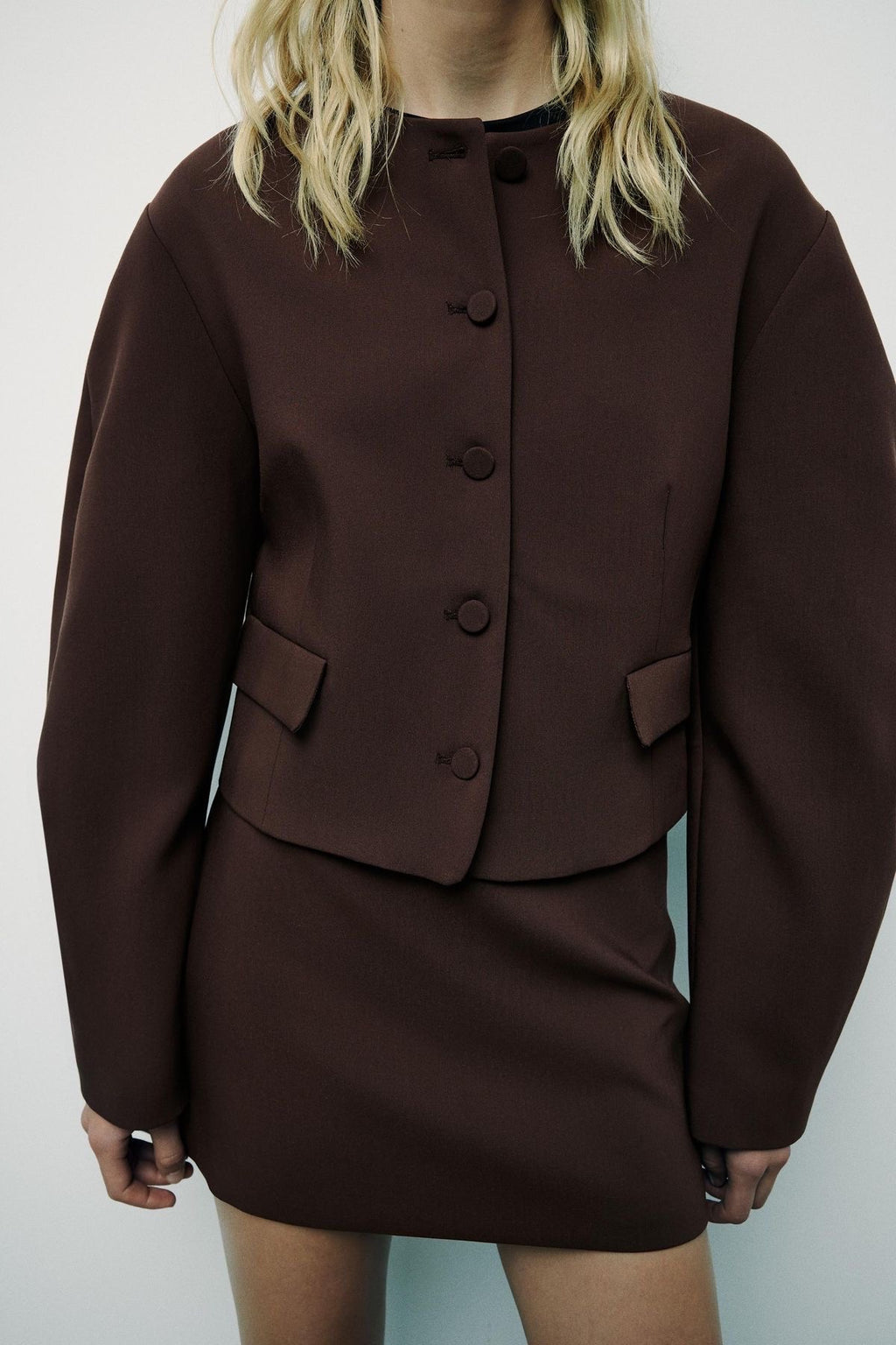 Brown suit with buttons on a plain background